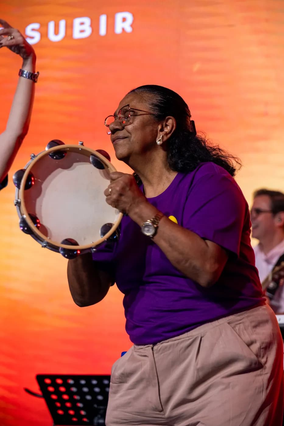 Participante tocando pandeiro durante a celebração