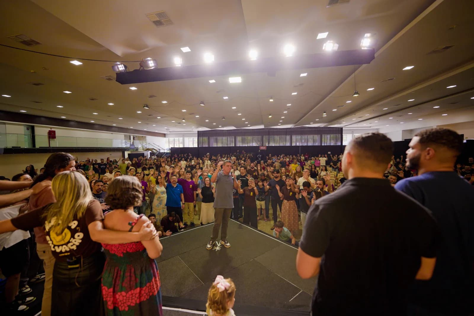 Igreja reunida diante do palco em um momento de oração