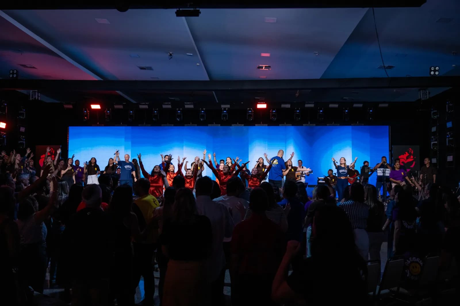 Palco iluminado e público reunido durante a Conferência Hertz 2025