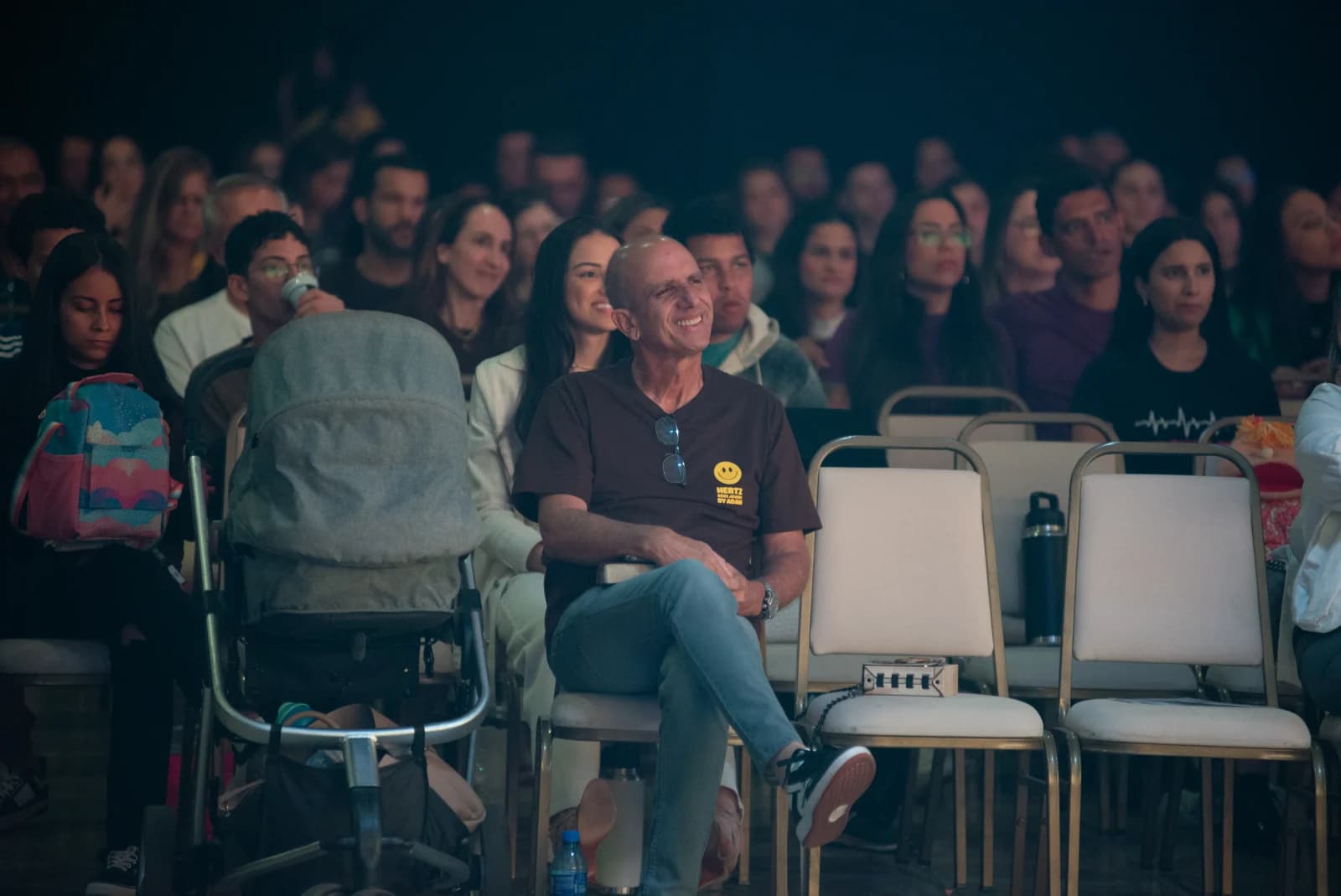 Pr. Márcio Simões sentado entre participantes durante a Hertz 2025