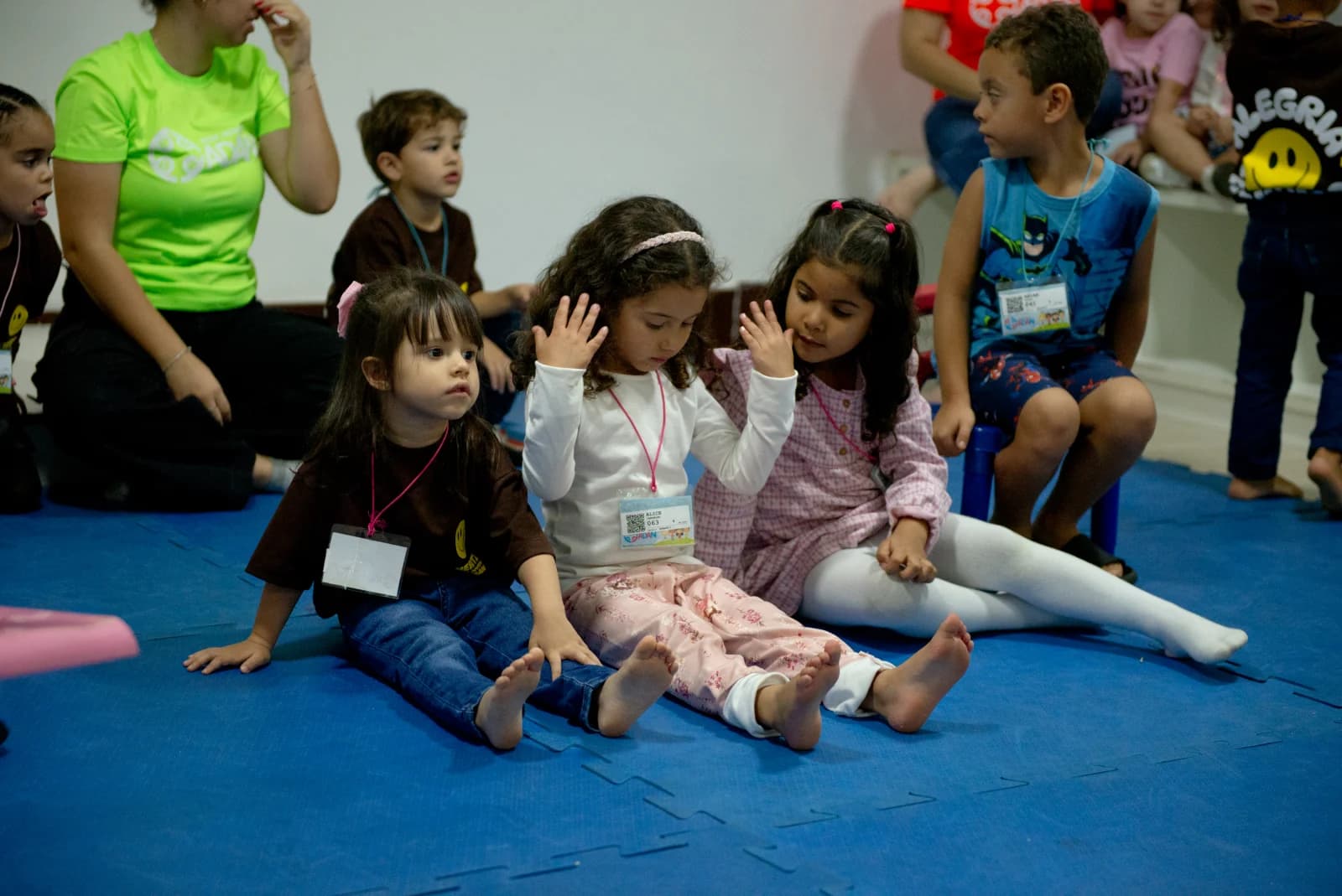 Crianças sentadas juntas em um momento de oração na Hertz Kids 2025